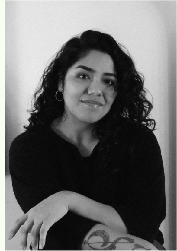 Sarah Espinoza, coach at The Voice Collective Co., photographed in black and white against a plain wall with her arms crossed